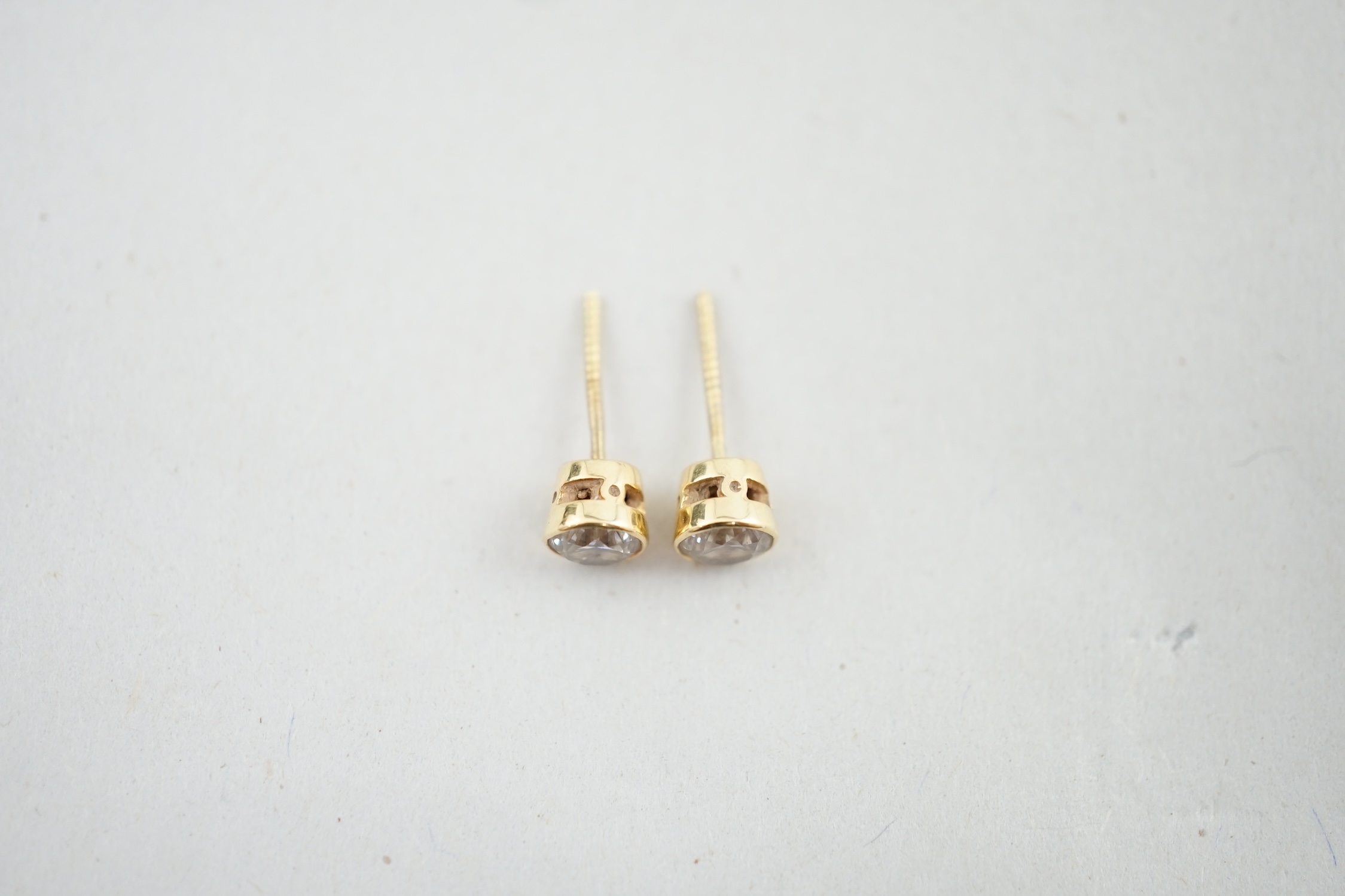 A pair of 18ct gold and collet set solitaire diamond ear studs